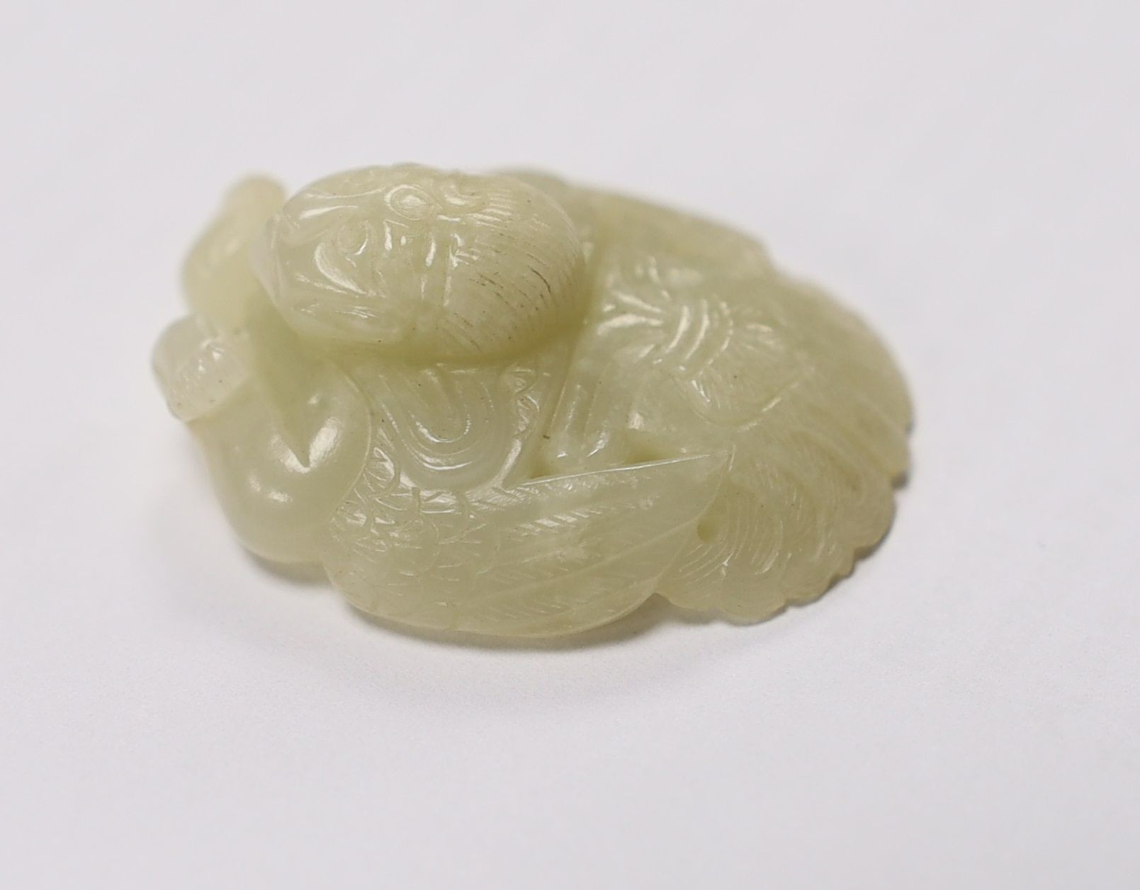 A Chinese pale celadon jade mount carved as a mythical half-man half-bird creature, 18th/19th century, 3.8cm high